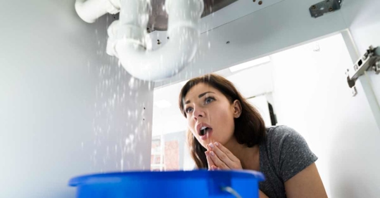 woman surprised by plumbing leak